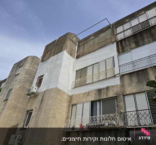 בניין עם מזגנים וחלונות תריסים